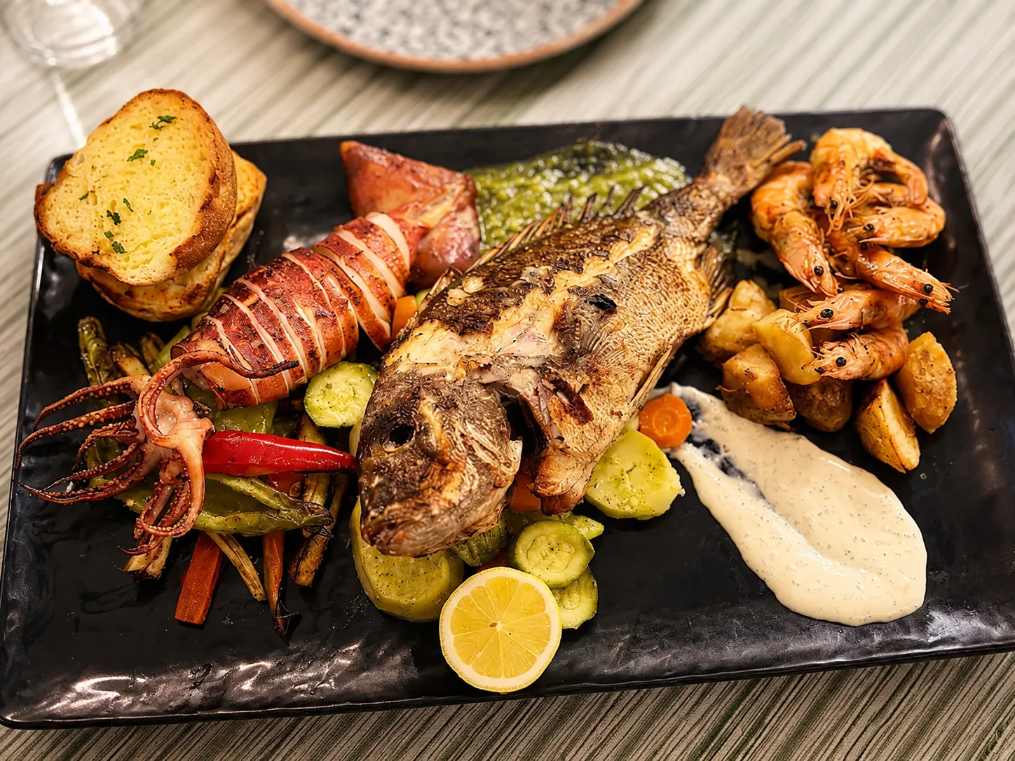 A char-grilled seafood platter — whole fish, langoustine, calamari and prawns